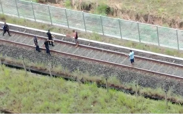 Imagem colorida de homens brigando nos trilhos do Metrô-DF
