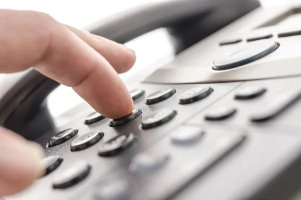 Imagem colorida mostra mão em teclas de telefone - Metrópoles