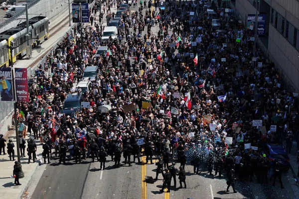 Foto colorida de manifestantes e polícia em Los Angeles - Metrópoles