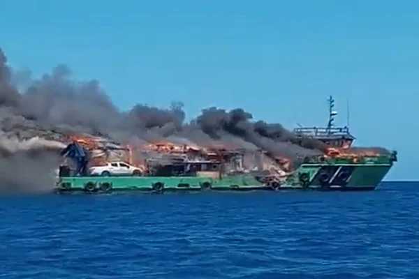 Imagem mostram embarcação verde em chamas. Do incêndio na embarcação, saem chamas e uma fumação preta | Metrópoles