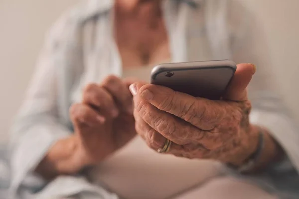 Mãos idosas mexendo no celular - limpo