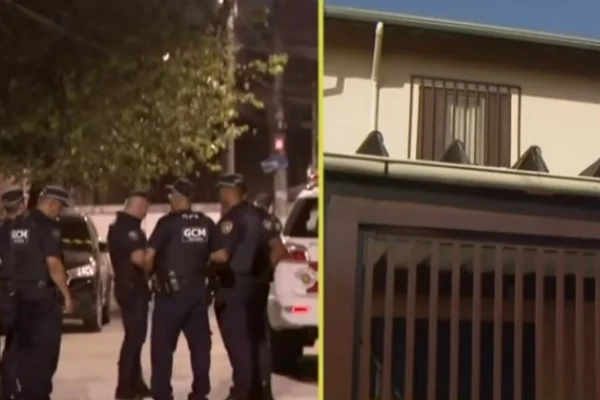 foto colorida de GCMs em frente à casa (à dir.) de adolescente que matou a família na Vila Jaguara, em SP - Metrópoles