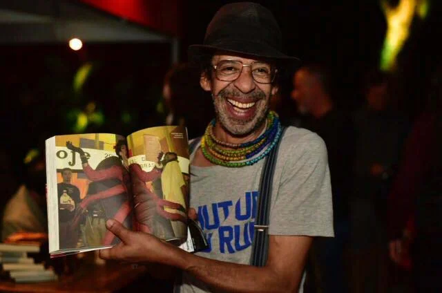 O performancer Jorge Dupan exibe sua foto no livro O performancer Jorge Dupan exibe sua foto no livro