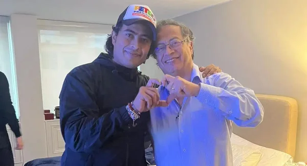 Foto mostra Nicolás Petro fazendo um coração com as mãos junto de seu pai, Nicolás Petro. O jovem usa casaco e o pai uma camisa social