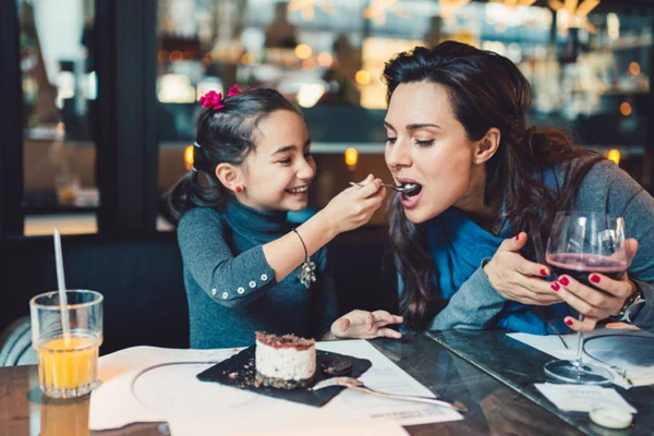 foto de criança dando comida na boca de mulher