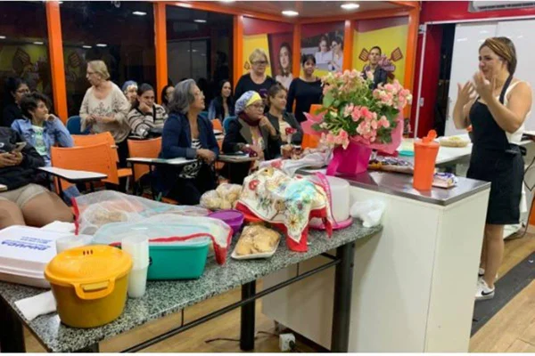 Imagem colorida de uma cozinha onde há várias pessoas nela