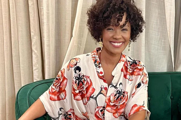 Isabel Fillardis posa, sorridente, com um vestido estampado - Metrópoles