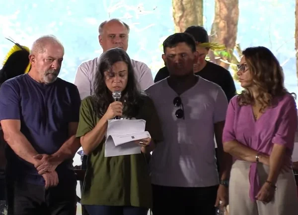 pessoas em palco e mulher discursando
