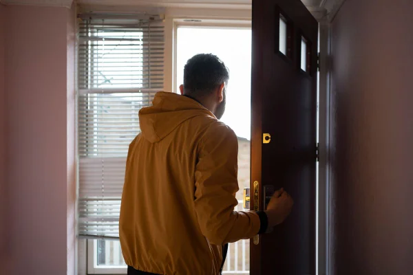 Foto colorida de um homem abrindo a porta - Metrópoles