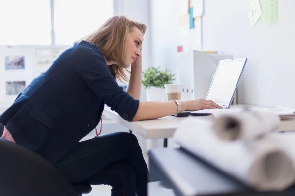 Foto colorida de mulher sentada em frente a computador - Metrópoles