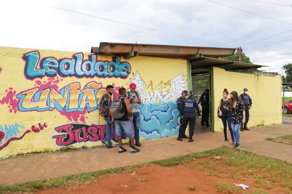 Pessoas em frente a muro colorido de escola