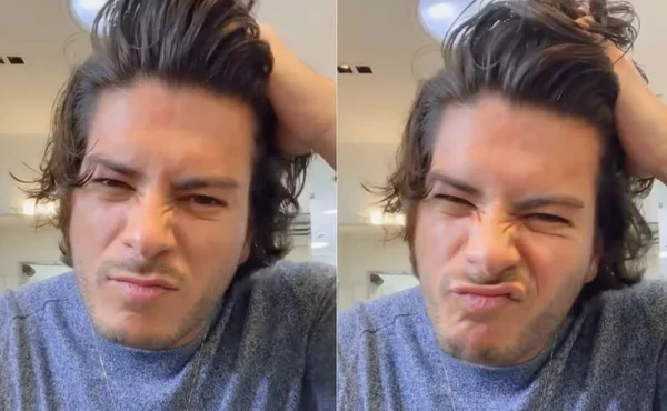 Arthur Aguiar mexendo no cabelo com camisa azul