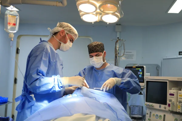 Fotografia colorida mostrando dois médicos durante cirurgia-Metrópoles
