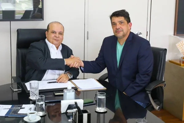 Robson Cândido, delegado-geral da PCDF que permanecerá no cargo no segundo mandato do governador Ibaneis Rocha. Na imagem, eles aparecem apertando as mãos sentados em mesa de reunião - Metrópoles