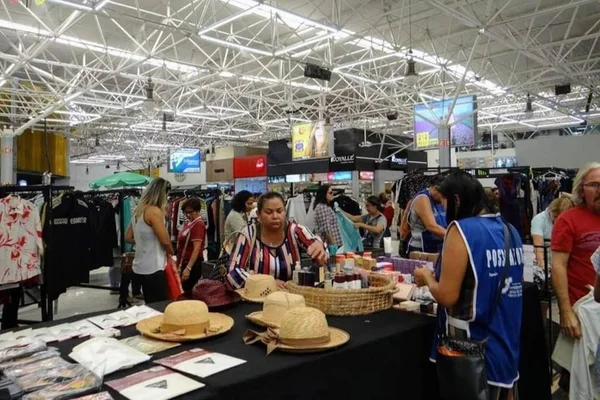 Foto colorida de pessoas em bazar no Gilberto Salomão