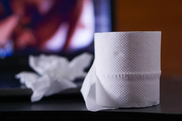 Rolo de papel higiênico com tv desfocada ao fundo - Metrópoles