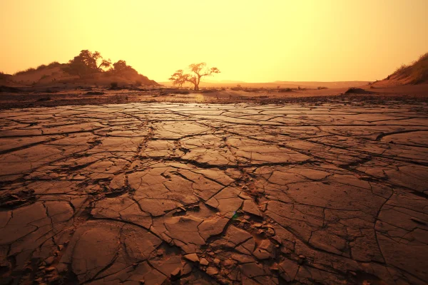 Foto colorida de ambiente aberto que mostra solo árido, seco e céu com sol forte - Metrópoles.