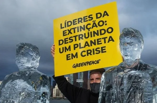 Ativista do Greenpeace com esculturas de gelo de Bolsonaro e TRump