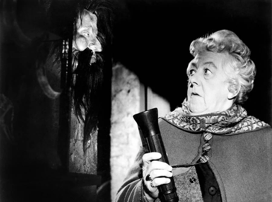 <b>”Quem Viu, Quem Matou…” (1961)</b>. A experiente atriz inglesa Margaret Rutherford praticamente se confunde com a detetive Miss Marple, personagem tão importante na obra de Christie quanto Poirot. No primeiro de quatro filmes lançados entre 1961 e 1964, todos dirigidos por George Pollock, ela é testemunha ocular de um assassinato e investiga o caso por conta própria após a polícia ignorar seu relato <b>”Quem Viu, Quem Matou…” (1961)</b>. A experiente atriz inglesa Margaret Rutherford praticamente se confunde com a detetive Miss Marple, personagem tão importante na obra de Christie quanto Poirot. No primeiro de quatro filmes lançados entre 1961 e 1964, todos dirigidos por George Pollock, ela é testemunha ocular de um assassinato e investiga o caso por conta própria após a polícia ignorar seu relato