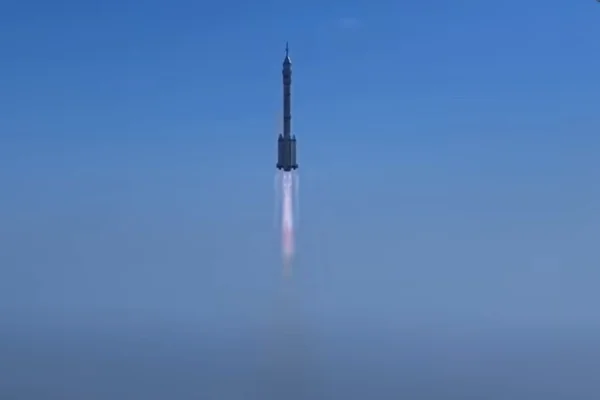 Print de vídeo do lançamento de um foguete chines. Na foto, céu azul e o foguete no meio de cor branca - Metrópoles.