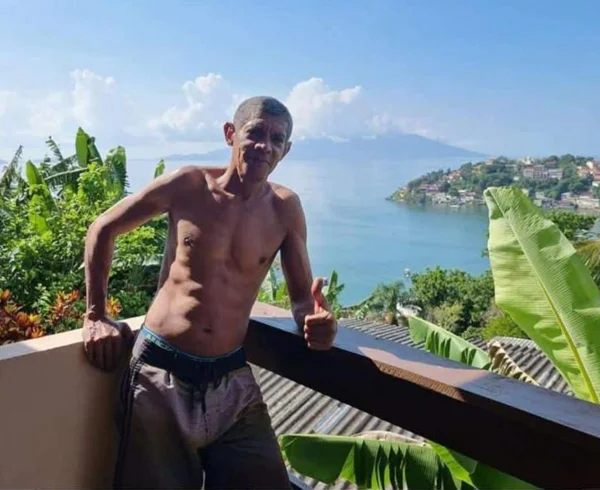 homem sem camisa em local com vista para o mar