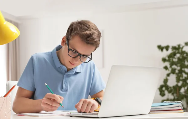 garoto adolescente estudando com lapis e computador
