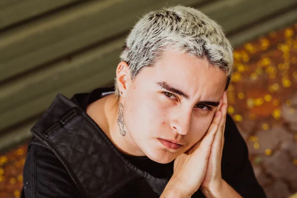 Na imagem com cor, homem branco de cabelos claros posa para foto com as duas mãos fechadas - Metrópoles
