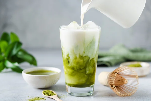 Imagem mostra copo com matcha, que é uma bebida verde, sendo misturado com leite - Metrópoles