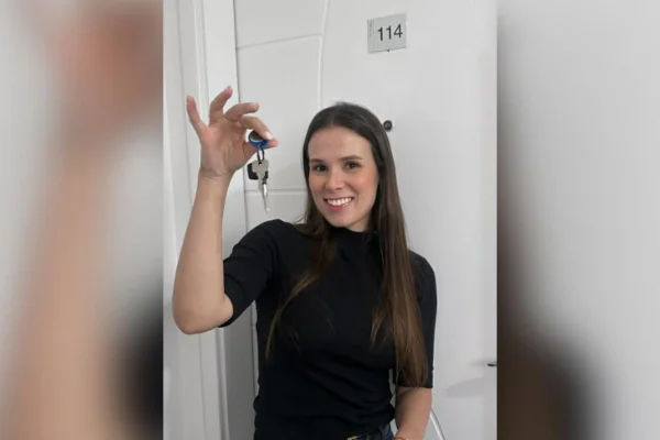 Imagem colorida mostra a influenciadora Jennifer Castro com a chave do novo apartamento em São Paulo - Metrópoles