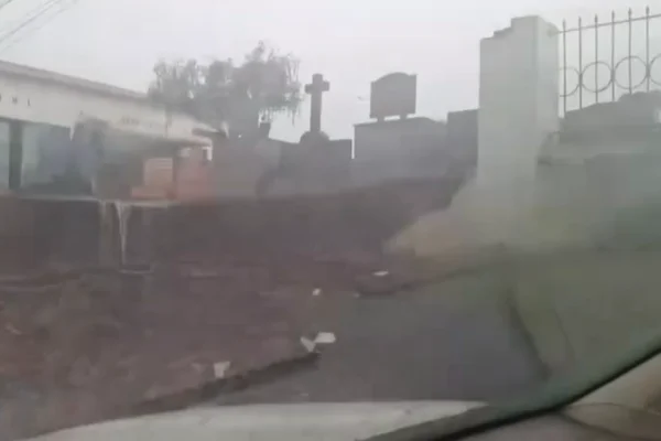 Imagem colorida de muro de cemitério que caiu com fortes chuvas. Metrópoles