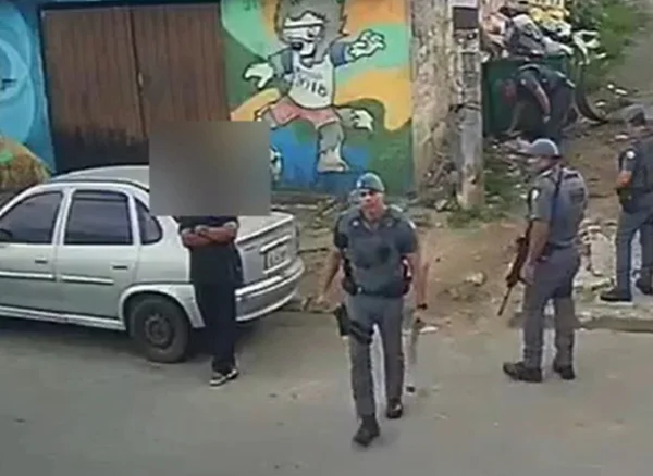 Imagem mostra policial com pedaço de madeira na mão - Metrópoles