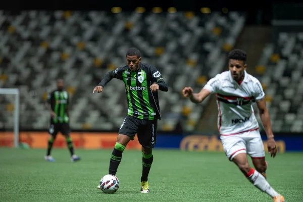 Jogador do América-MG conduz a bola durante duelo contra o Botafogo-SP.