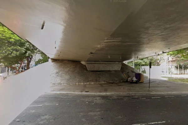 Imagem colorida de calçada com carrinho de mão sob viaduto em cruzamento - Metrópoles
