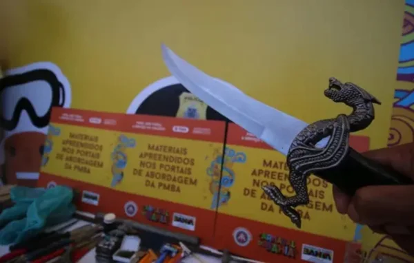 espada com cabo adornado, ao fundo outros objetos