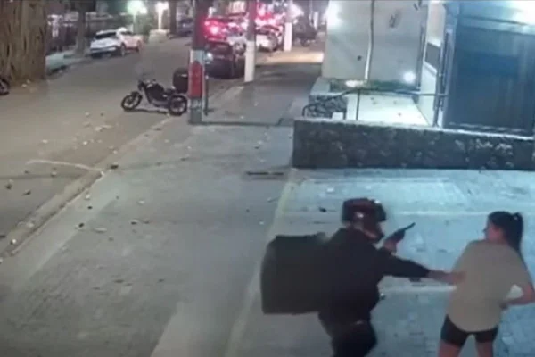 Imagem colorida mostra motociclista apontando arma para mulher durante assalto/roubo em rua de Pinheiros - Metrópoles