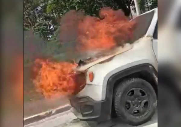 Imagem colorida de carro branco em chamas