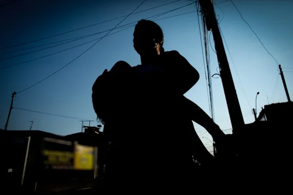 Mulher na contra-luz segurando criança