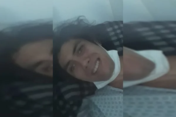 Homem sorrindo com máscara no queixo