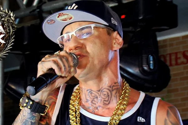 Foto colorida do MC Danilo Boladão cantando em um show