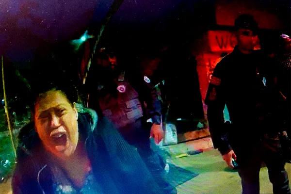 Mulher com boca aberta do lado esquerdo, gritando, ao lado de PM fardado - Metrópoles