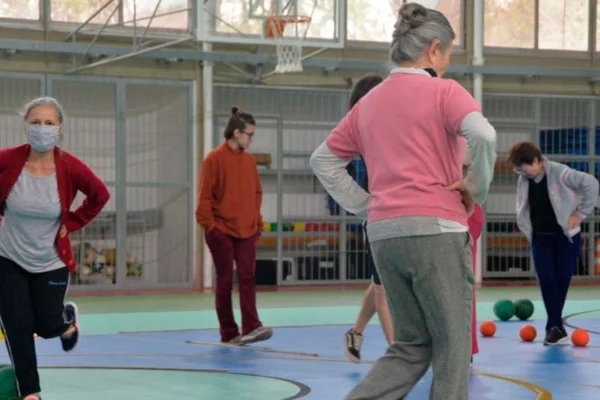 Imagem colorida de mulheres idosas fazendo exercícios de equilíbrio em ginásio. Metrópoles