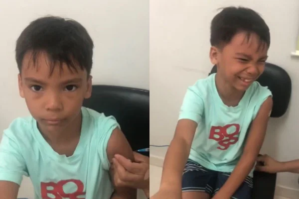 Foto colorida de um menino tomando vacina - Metrópoles