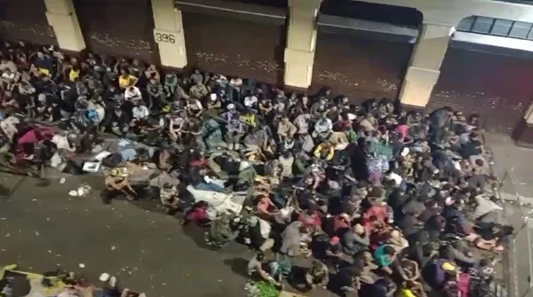 foto colorida feita do alto de um prédio na Cracolândia mostra usuários de drogas reunidos e sentados em uma rua da região durante a madrugada