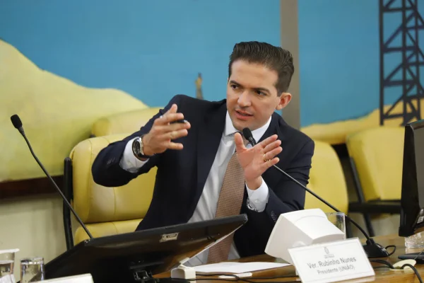 Imagem colorida mostra Rubinho Nunes, homem branco, de terno e gravata, em uma mesa de audiências, falando ao microfone - Metrópoles