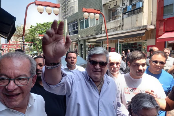 Grupo de pessoas caminha em rua com luminárias orientais - Metrópoles