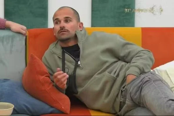 foto colorida de homem deitado em sofá laranja