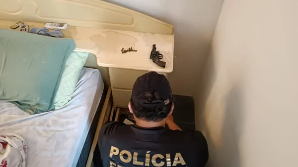 Imagem colorida de agentes da PF e arma sobre cômoda - Metrópoles