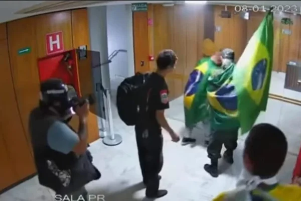 Foto colorida do momento em que o repórter fotográfico Adriano Machado da Agência Reuters tira foto de bolsonaristas no Palácio do Planalto - Metrópoles