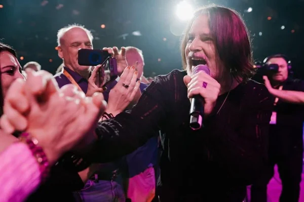 Imagem colorida de Tommy DeCarlo, vocalista do Boston, cantando em show - Metrópoles