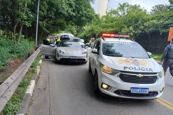 Imagem colorida de Porsche abordado por viatura da PM. Metrópoles